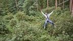 Man on zip wire with arms in the air